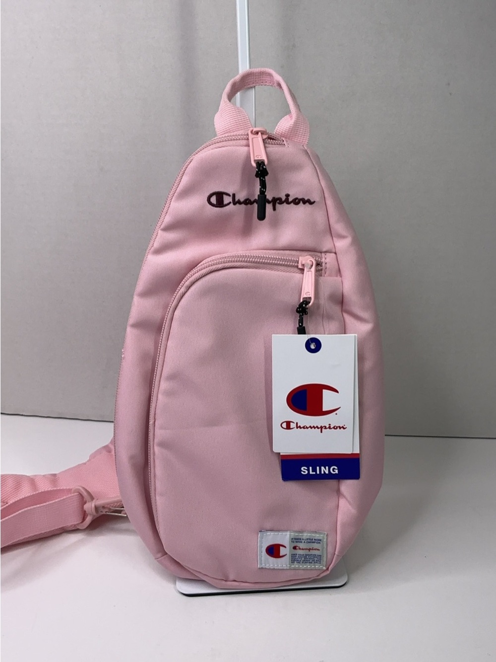 Champion Method sling pink handbag features a prominent embroidered logo.